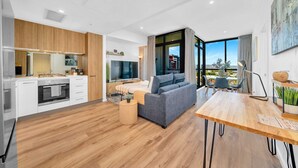 A modern apartment with a kitchen, living area, and dining space. - Luxe on Franklin | Car Park, Lap Pool, Sauna, BBQ (Adelaide)