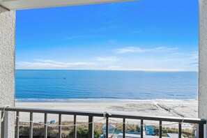 Un balcon avec vue sur la plage et l’océan.