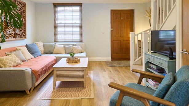 A living room with a sofa, a coffee table, a TV stand, and a bookshelf. - Host & Stay | Aurora (Deal)