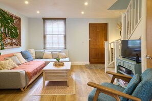A living room with a sofa, a coffee table, a TV stand, and a bookshelf. - Host & Stay | Aurora (Deal)