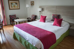 A hotel room with a large bed, a desk, two chairs, and a nightstand. - Hotel de la Poste - Benjamin Linard  (Pouilly-en-Auxois)