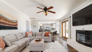 Una sala moderna con un sofá modular, un reposapiés y una chimenea.
