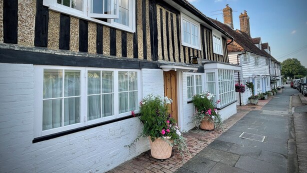 A row of traditional half-timbered houses with white-painted exteriors and multiple windows.