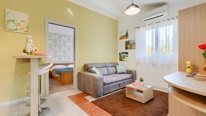 A modern living room with a sofa, a small table, a bed, and artwork on the walls. - Villa Mir - Rovinj by Villas Guide (Rovinj)