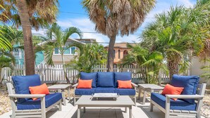 An outdoor seating area with a blue sofa set and matching armchairs, a coffee table, and a white picket fence in the background. - ☀️ Pet Friendly - Entire Property - The Bungalows ☀️ (Treasure Island)