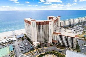 Ein Hochhaus-Hotel mit mehreren Etagen, einer Tiefgarage und Blick auf den Strand.