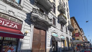 A building with ornate architectural details and a pizza restaurant named "Overreto Turkish Pizza" on the ground floor. - [Modern] 2BR/2BA • Metro Access • 12min Duomo (Milan)