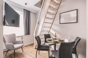 A modern interior with a dining area, a staircase, and a framed artwork on the wall. - Estrella 12 - Stylowy Loft z Antresol w Sercu Torunia (Torun)