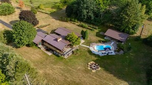 Vista aérea de una propiedad con varias edificaciones, piscina y zona con fogata.