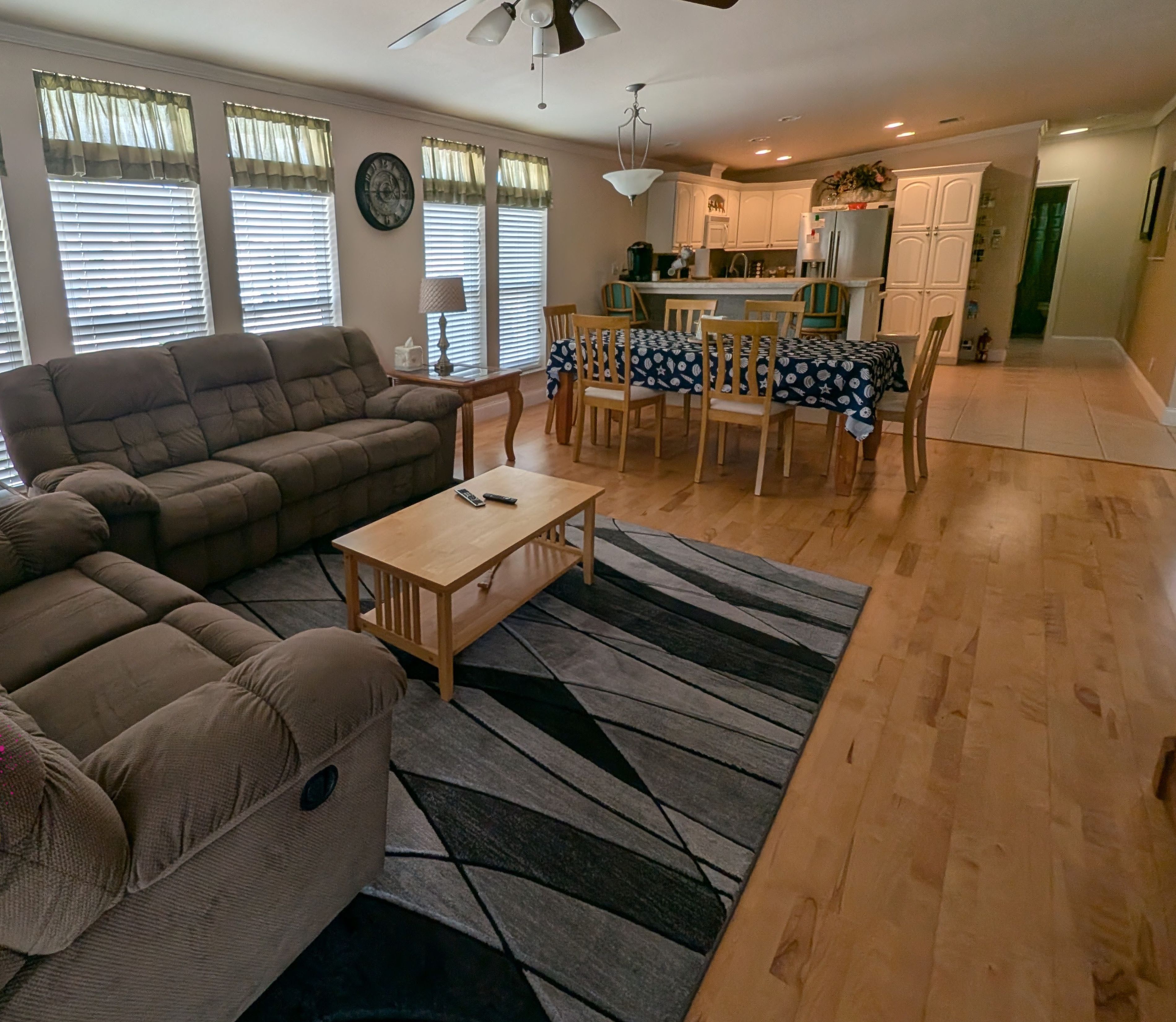 A living room with a sofa, a coffee table, and a dining area with a table and chairs.