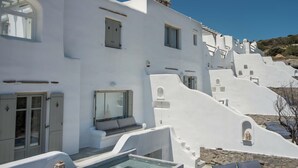 Un edificio bianco con piscina e lettini.