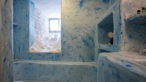 Un bagno con una parete azzurra e strutturata e una finestra.