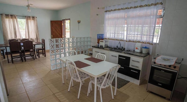 A kitchen with a dining area, a stove, and a refrigerator.