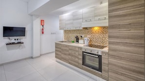A modern kitchen with a flat-screen TV, a coffee machine, and a toaster. - Spacious Paceville fully equipped home w/WIFI (St. Julian`s)