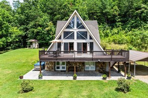 A large, two-story house with a prominent triangular roof, a covered porch, and a small adjacent structure. - Smoky Everest 4 Bedroom Chalet (Newport)
