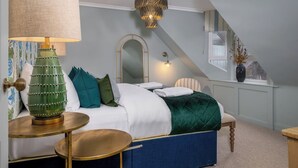 Et soveværelse med seng, lampe, spejl og et vindue med udsigt.