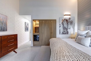 A bedroom with a wooden wardrobe, a bed with a textured blanket, and a wall-mounted light fixture. - Ski Captain Molly 3 Bedroom Condo (Park City)