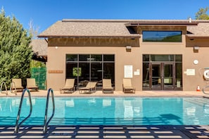 A building with a swimming pool, lounge chairs, and a large window. - Ski Captain Molly 3 Bedroom Condo (Park City)
