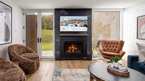 A modern living room with a fireplace, a large flat-screen TV, and a cozy seating area. - Ski Captain Molly 3 Bedroom Condo (Park City)