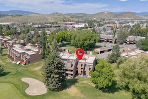 An aerial view of a residential area with modern buildings, green spaces, and a golf course. - Ski Captain Molly 3 Bedroom Condo (Park City)