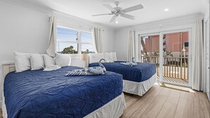 A hotel room with two beds, a ceiling fan, and a view of the outside. - Vacation Villas #131 2 Bedroom Condo (Fort Myers Beach)