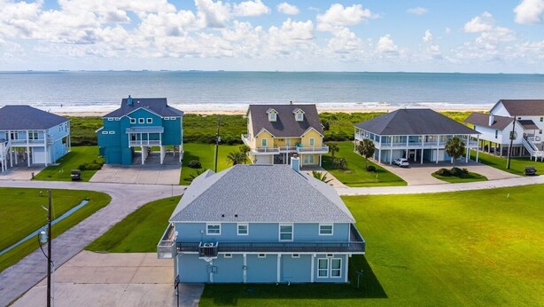 Uma área residencial à beira-mar, com casas e uma praia ao fundo.