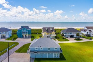A coastal residential area with houses and a beach in the background. - Happy Hours 4 Bedroom Home (Port Bolivar)