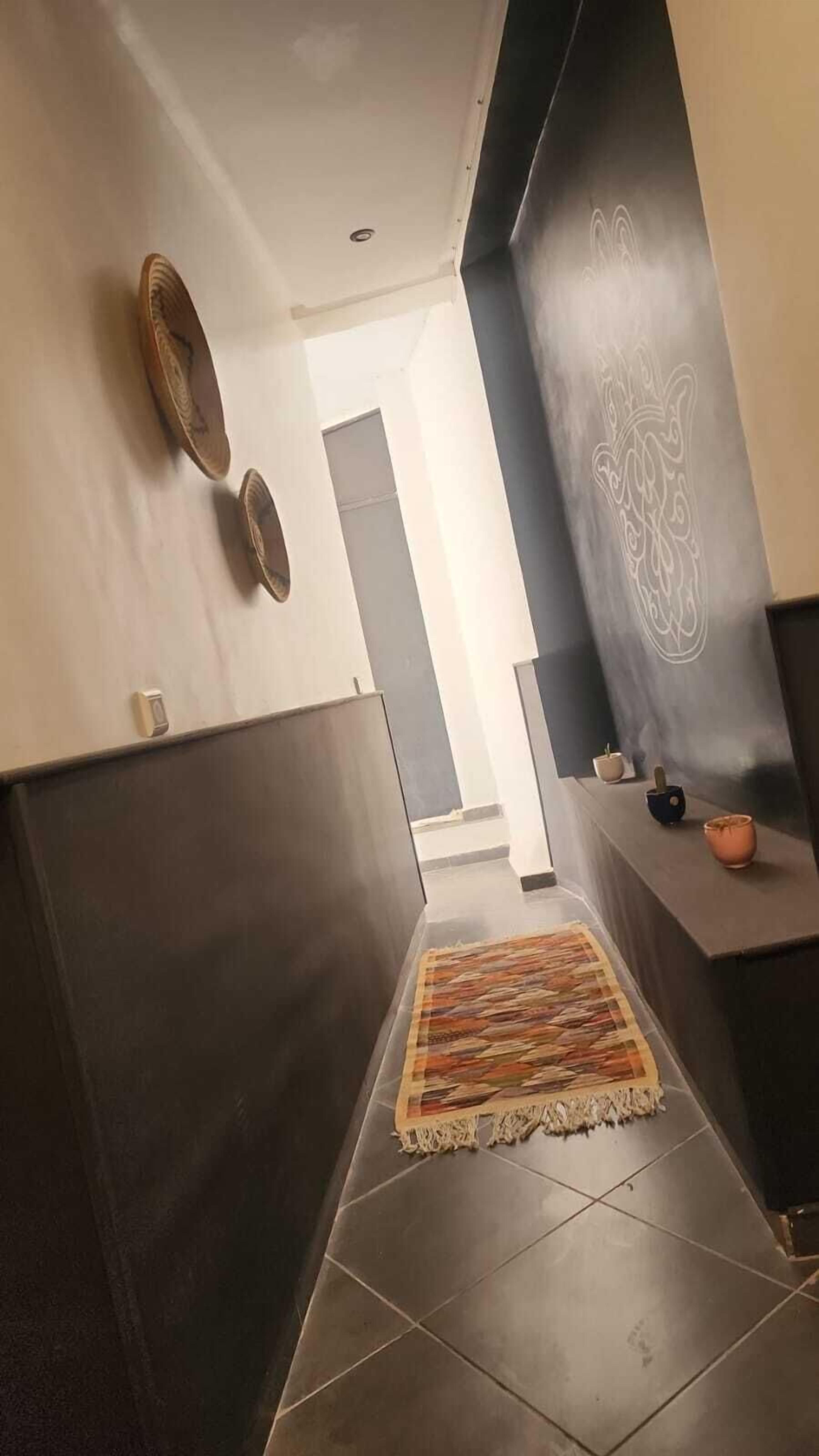 Een moderne hal met een kamerbreed tapijt, donkere wanden en een minimalistisch design.