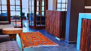 Ein modernes Interieur mit einem Fellteppich, einer gepolsterten Couch und Pendelleuchten.