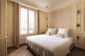 A hotel room with a large bed, a window with curtains, and a door with a handle. - Merveil Luxury Suite - Marais - Ponceau (Paris)