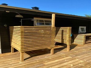 A wooden deck with a built-in bench and a window overlooking the deck. - 5 Star Holiday Home in Knebel (Knebel)