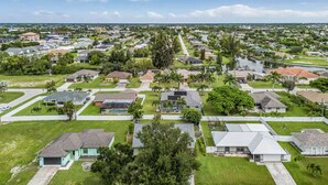 An aerial view of a residential area with houses, green lawns, and trees. - Al Capone - Paradise Apartment (Cape Coral)