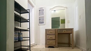 A narrow hallway with a wooden desk and a metal shelving unit against the wall. - Al Capone - Paradise Apartment (Cape Coral)