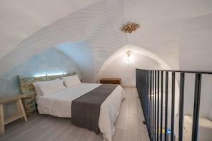Une chambre à coucher avec un lit, une table de chevet et un banc en bois.