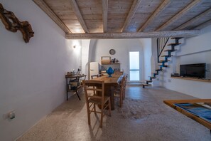 A spacious kitchen with a wooden table and chairs, a refrigerator, and a clock on the wall. - Amazing Apartment "Alla Corte" with pool and sauna (Taurisano)