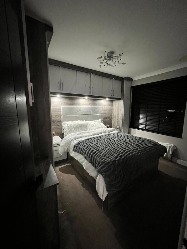 Une chambre à coucher avec un lit, une table de chevet et une armoire.