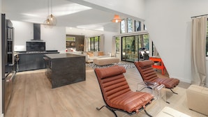 A spacious living area with a kitchen, a dining area, and a seating area with leather chairs. - A Place and Time Blue Ridge GA (Blue Ridge)