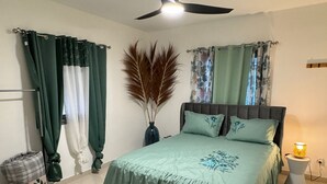 A bedroom with a bed, a ceiling fan, and a bedside lamp. - VILLA LAZUREA located in the heart of Terre-Sainte on the main avenue (Saint-Pierre)