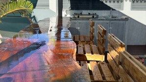 A wooden outdoor bar with a rustic design, a grill, and a covered seating area. - VILLA LAZUREA located in the heart of Terre-Sainte on the main avenue (Saint-Pierre)