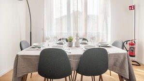 A dining area with a table set for four, a fire extinguisher, and a lamp. - luxury suite Como (Como)