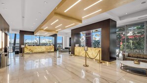 A spacious lobby with a marble floor, a reception desk, and a seating area. - Between Lakes and Ocean For 4 (Hollywood)