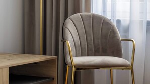Une pièce avec une chaise, un bureau et un lampadaire.