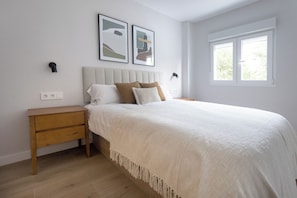 A bedroom with a bed, nightstands, a window, and wall-mounted artwork. - A three-bedroom in Tetuán with its own outdoor space and a separate guest house with a workspace, near La Ventilla park and the Castellana. (MADRID)