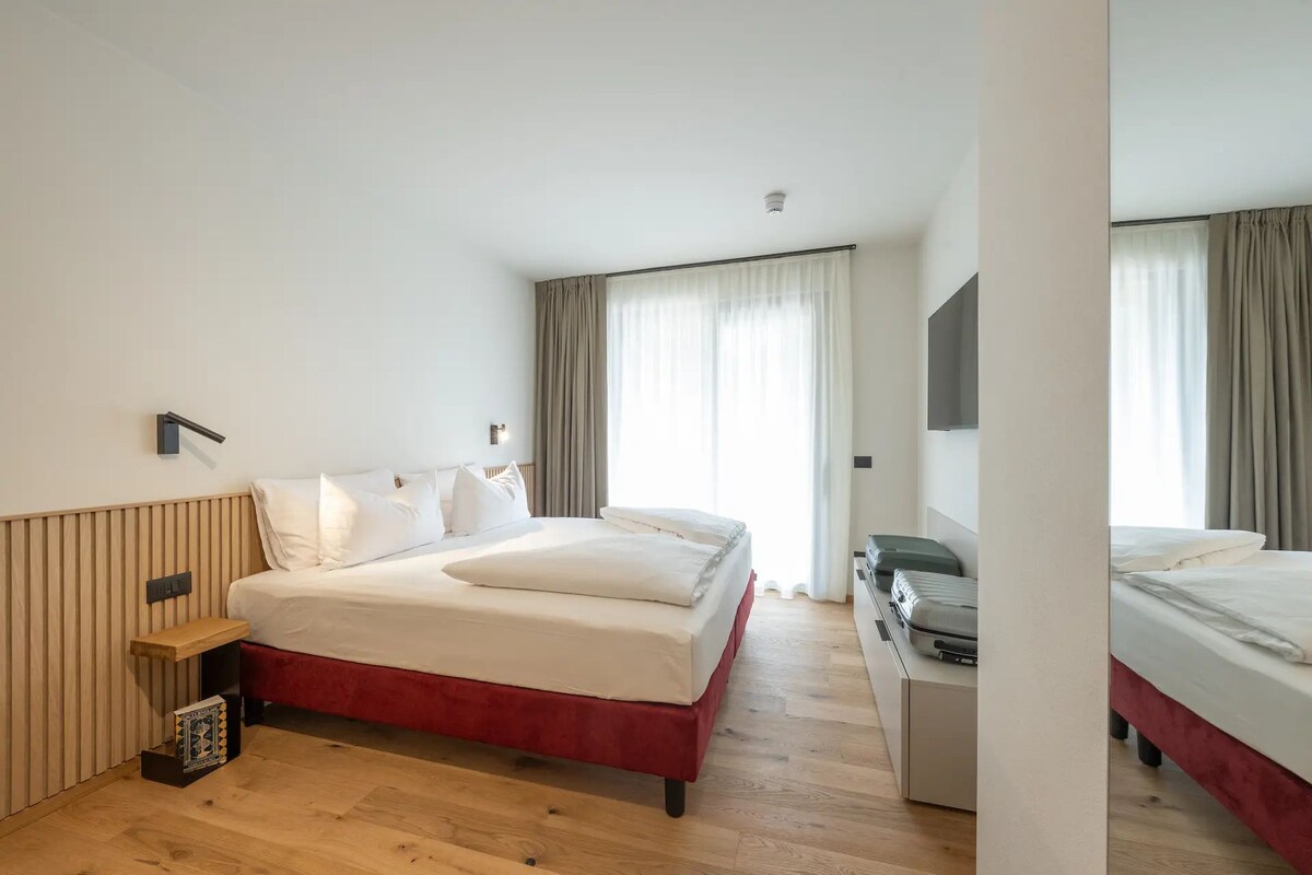 Una habitación de hotel con una cama grande, un escritorio y una silla.