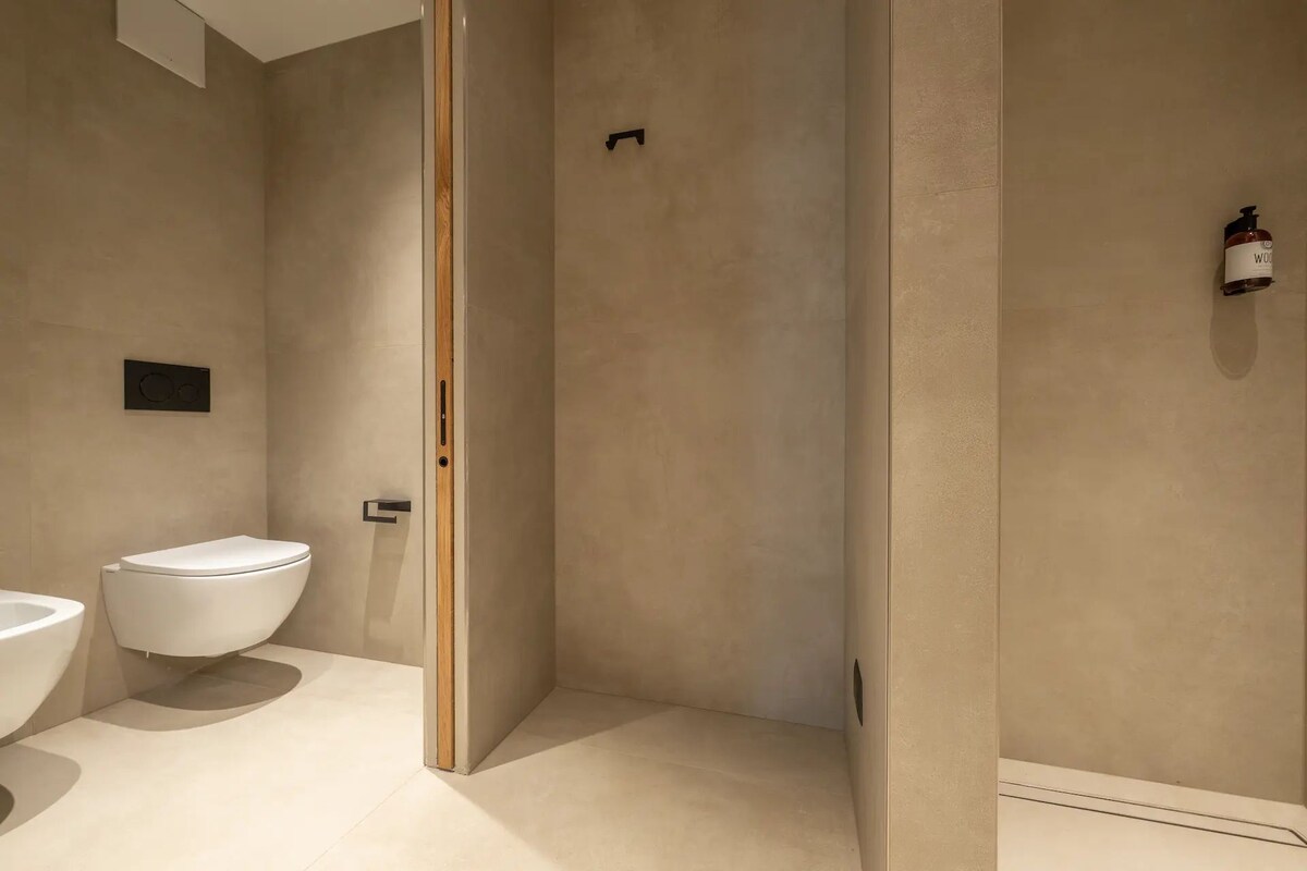 Un baño moderno con inodoro, ducha y lavamanos.