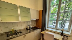 A compact kitchen with a window, a sink, and a small workspace. - Fantastic Inn Warsaw - NS38 (Warsaw)