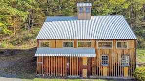 A wooden cabin with a metal roof, multiple windows, and a chimney.