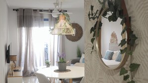 Un comedor moderno con una mesa redonda, sillas tapizadas grises y una lámpara colgante.