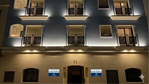Un immeuble à plusieurs étages doté de balcons et de fenêtres, portant l’inscription « APARTAMENTOS BLUE SUITES ALICANTE ».