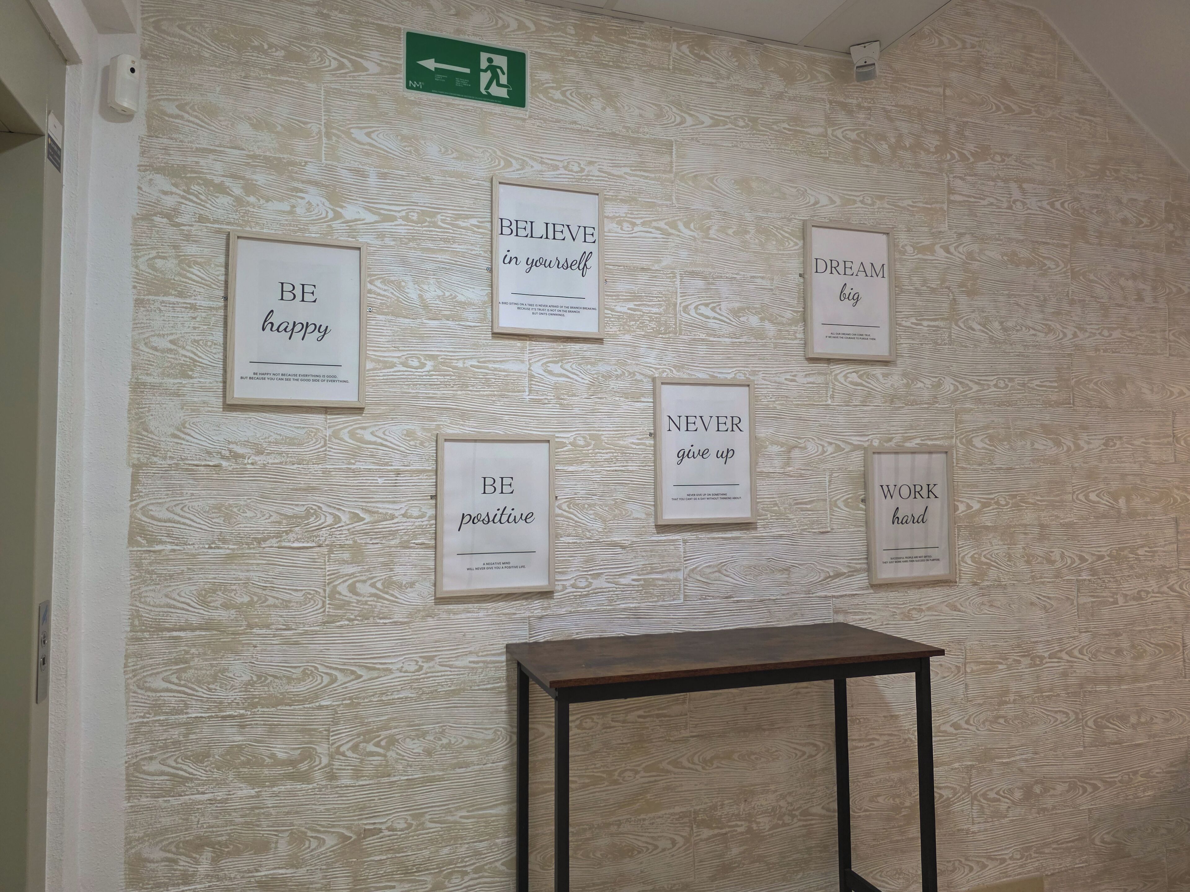 Eine Wand mit Motivationspostern und einem Wegweiser.